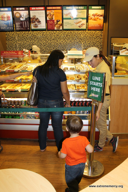 Elijah got in line by himself at Krispy Kreme  hoping to get a doughnut.